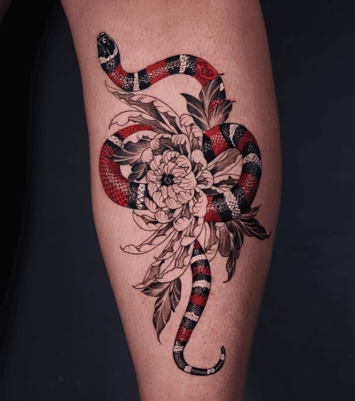 Xăm hình rắn san hô đỏ đen, tattoo hoa khắc đẹp, xăm đùi đen xám đỏ: Rắn sọc đỏ đen ôm khóm hoa khắc nét, vừa cổ điển vừa rực rỡ.