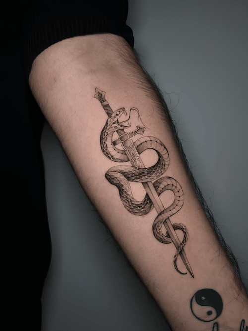 Xăm hình rắn quấn kiếm, tattoo biểu tượng đẹp, xăm cẳng tay nam, chi tiết vảy rắn: Rắn quấn quanh lưỡi kiếm sắc, biểu trưng sức mạnh và bảo hộ.