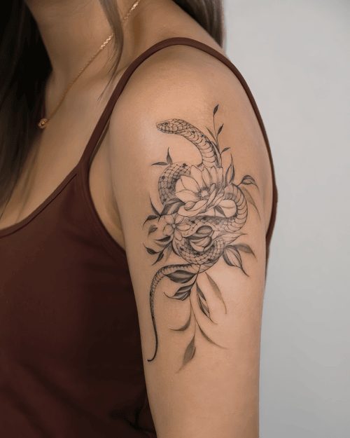 Xăm hình rắn và hoa, fine line tattoo đẹp, xăm vai nữ, nature tattoo đen xám: Rắn quấn khóm hoa mảnh, đường nét tinh vi cho cảm giác dịu mà sang.