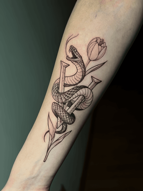 Xăm rắn và hoa tulip, hình xăm đen xám, tattoo cẳng tay đẹp, geometric contrast: Rắn quấn quanh tulip và cọc nhọn, nữ tính xen chút nổi loạn.