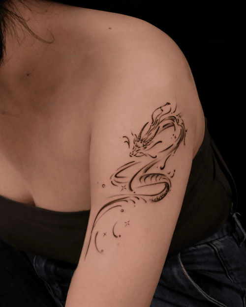 Xăm hình rồng mini cho nữ ở vai - Hiện thân của sức mạnh và may mắn, biểu tượng quyền lực và sự bảo hộ trong văn hóa phương Đông.