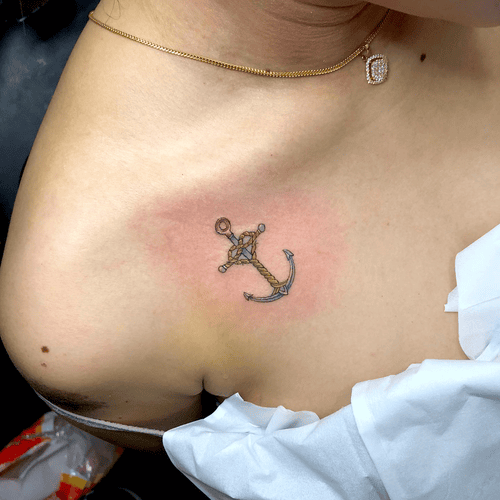 Xăm hình mỏ neo mini cho nữ ở vai - Biểu tượng của sự ổn định và bình yên, là điểm tựa vững chắc giữa những sóng gió cuộc đời.