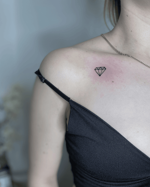 Xăm hình kim cương mini cho nữ ở vai - Biểu tượng của sự quý giá và bền vững, phản chiếu ánh sáng nội tâm và giá trị bất biến.