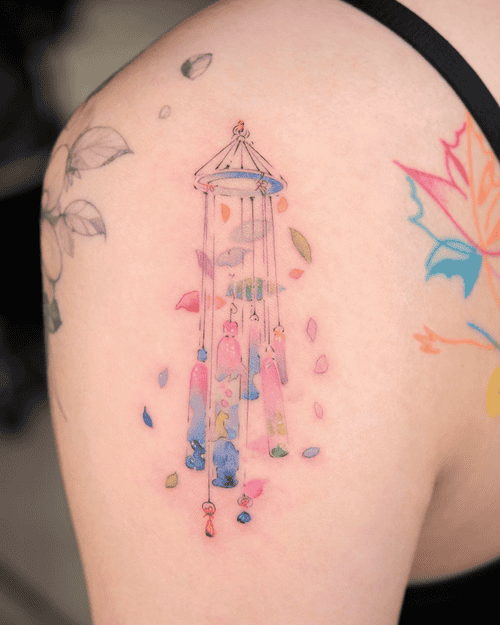 Xăm hình chuông gió mini cho nữ ở vai - Biểu tượng của sự thanh thản và hài hòa, mang đến âm thanh êm dịu giữa những ồn ào của cuộc sống.