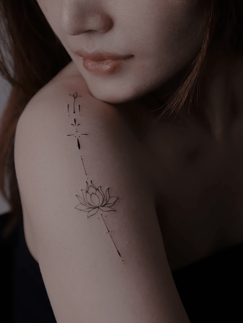 Xăm hình hoa sen mini cho nữ ở vai - Hiện thân của sự tinh khiết, sinh ra từ bùn nhưng vươn lên ánh sáng với vẻ đẹp thanh cao.