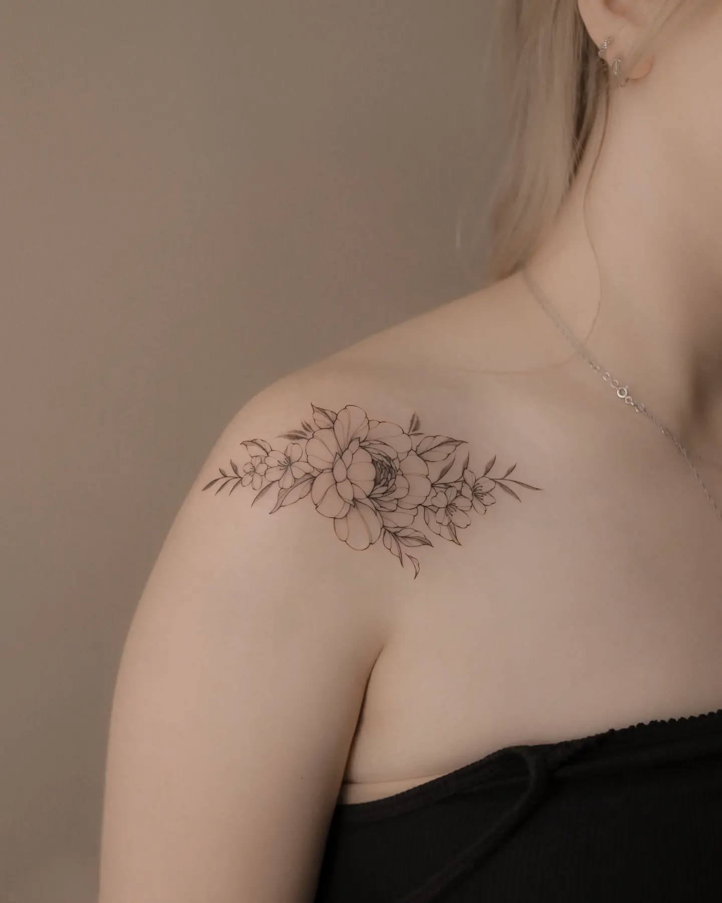 Xăm hình hoa mẫu đơn mini đẹp cho nữ ở vai - Biểu tượng của sự giàu có và cao quý, thể hiện vẻ đẹp kiêu sa và phẩm giá của người phụ nữ.
